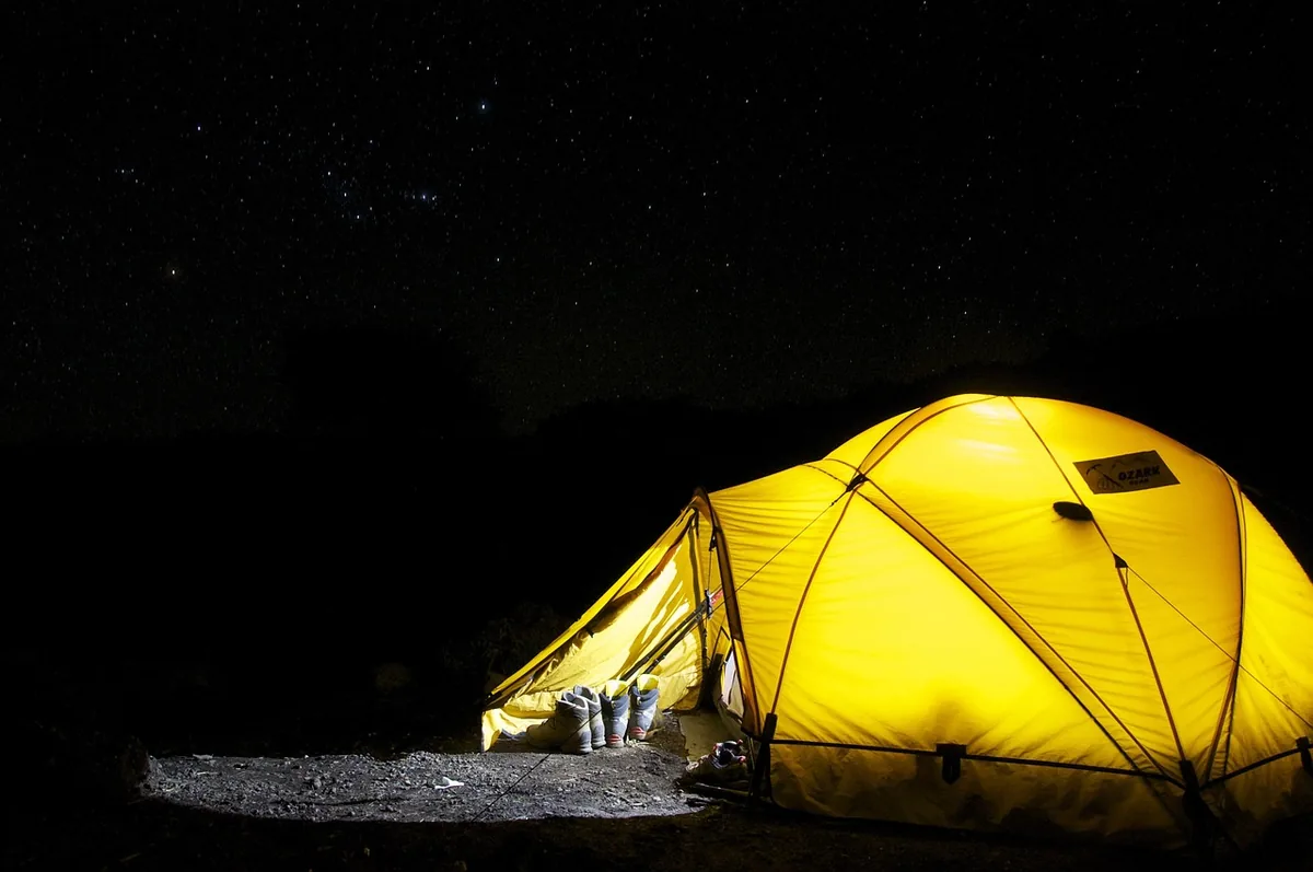 A tent set up outdoors at night