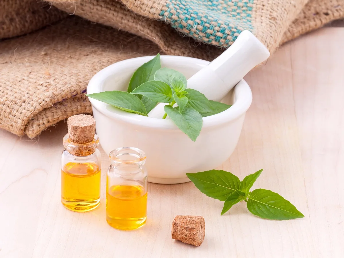 Small bottles of essential oil beside plants