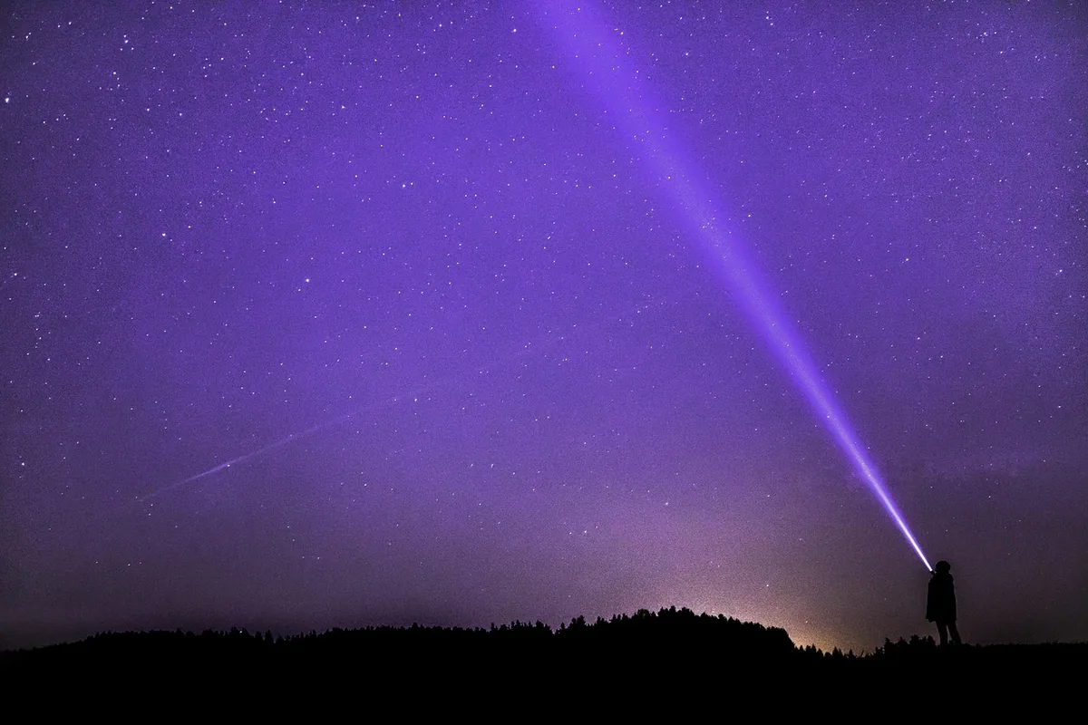 A flashlight beam shining into a dark space