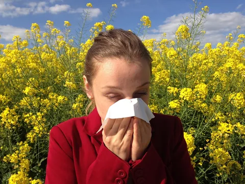 A person sneezing into a tissue at home