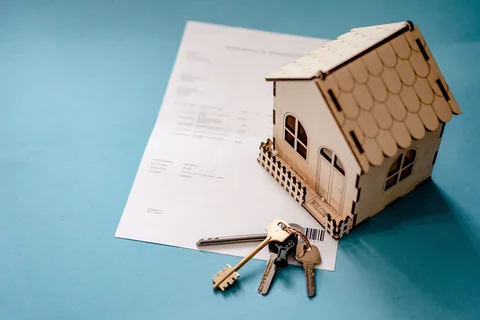 A model house with keys and paperwork