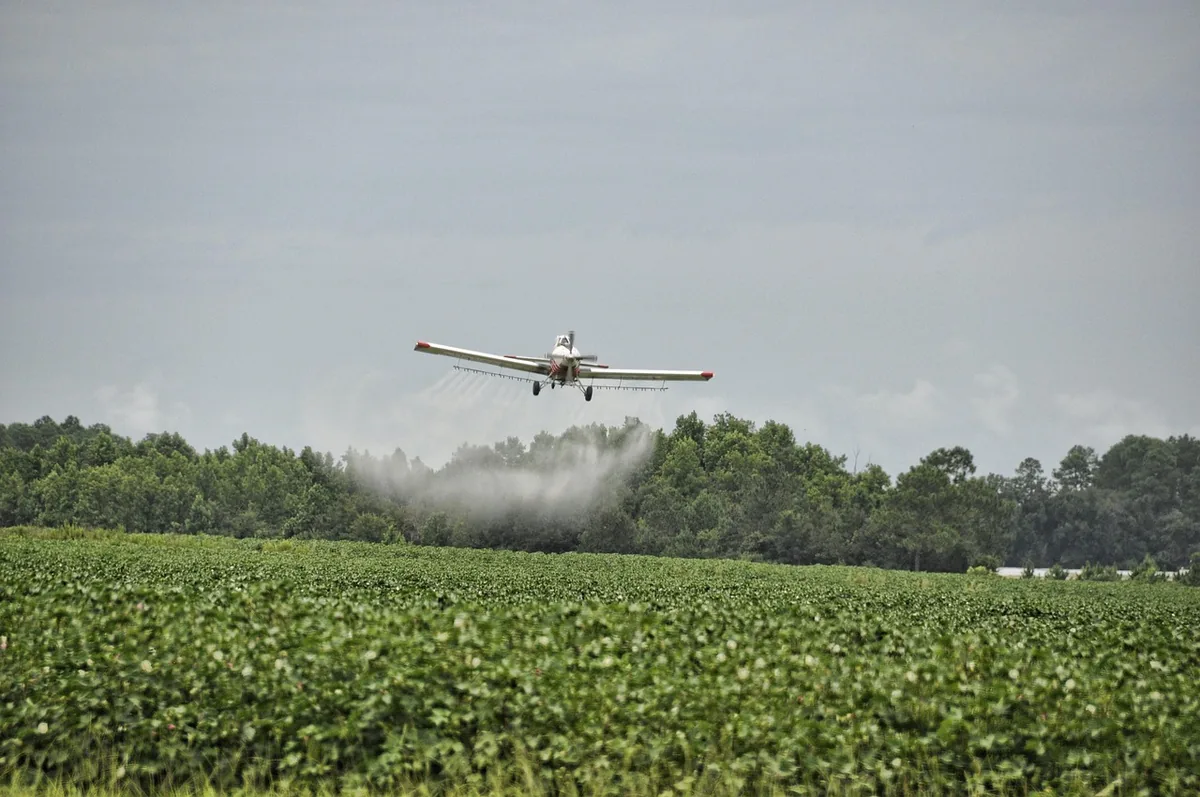 A crop-dusting plane spraying a field